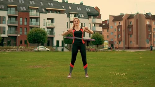 Woman Exercising With a Hula Hoop in Park