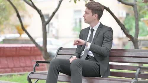 Man in Suit Waiting on Park Bench