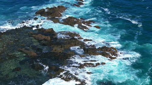 Aerial View of Waves Crashing on Rocky Coast