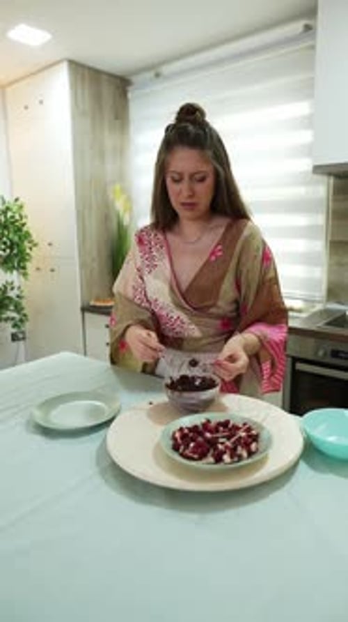 Woman Dips Fruit in Chocolate at Kitchen Table