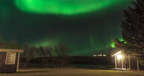 time lapse of northern lights in iceland over houses
