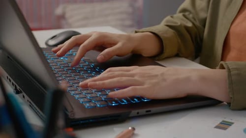 Woman working from home typing on laptop in modern workspace