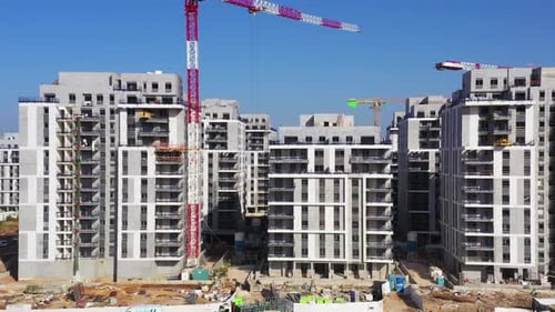 Chantier de construction résidentiel avec grues et construction en cours, vue aérienne.
