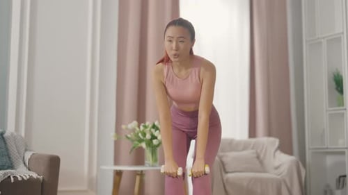 Woman Working Out with Dumbbells in Living Room