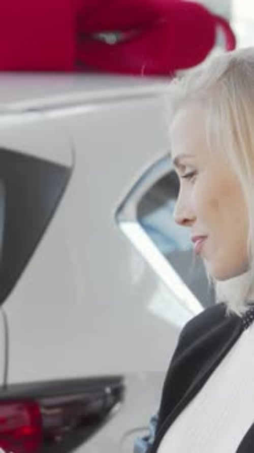 Charming Woman Smiling Brightly While Holding Car Keys in a Dealership