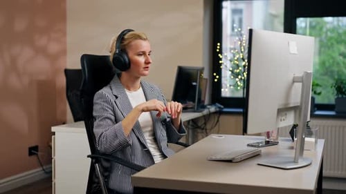 in a Bright Office Young Blonde Employee Works at a White Monitor on a Light Table Modern Office Sun