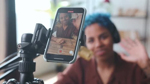 Woman Recording Herself Speaking into Microphone at Desk