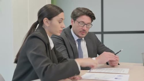 Business People Discussing Business Report in Office, Paperwork