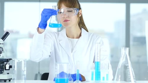 Woman Scientist Working in a Laboratory with Beakers