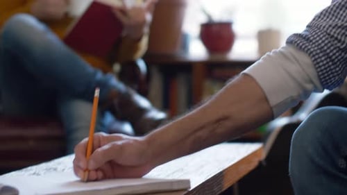 Man Playing Guitar, Another Writing Music in Home