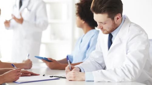 Medical Professionals Collaborate in Meeting, Taking Notes