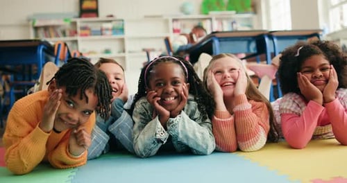 School kids, group and face on floor in classroom, laugh and excited for education at academy