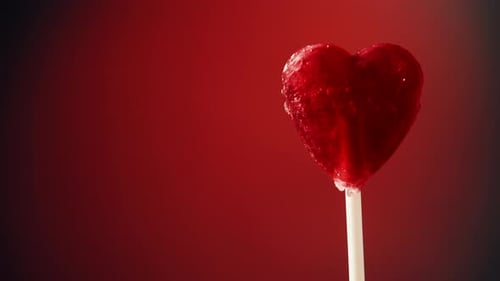 Heart Shaped Lollipop Rotating on Red Background