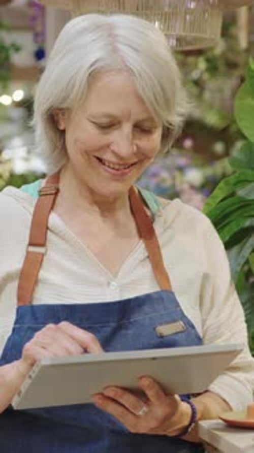 Florist Using Digital Tablet in Flower Shop in Slow Motion