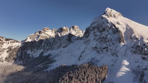 Aerial view of Fronalpstock, Kanton Glarus, Switzerland, showcasing snow-covered peaks.