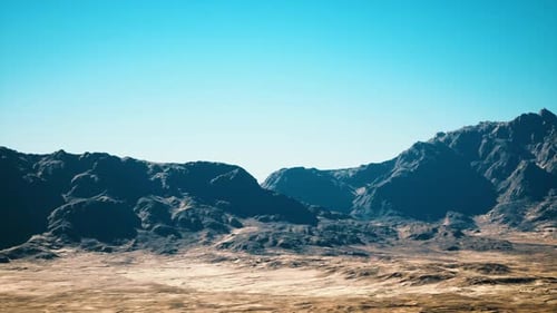 Clear Daylight Illuminates Rugged Desert Landscape with Scattered Boulders