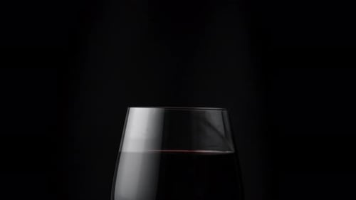 Drop of Red Wine Falling in Glass