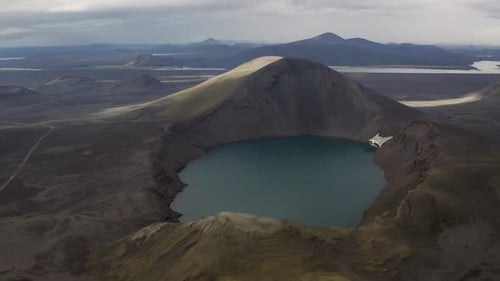 Drone flight over beautiful Crater lake surrounded by black sand desert on Iceland Island during