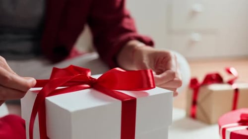Wrapping a Christmas Gift with a Red Ribbon