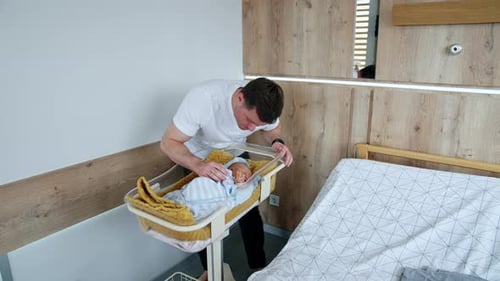 Father Gazing Lovingly at Newborn Baby in Hospital