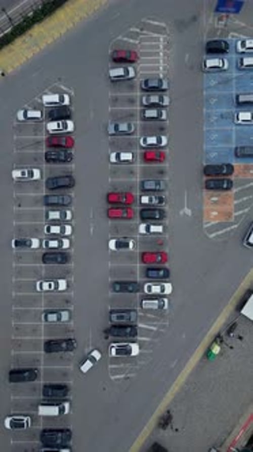 Aerial View of a Busy Parking Lot Filled with Various Cars During Daylight in an Urban Area