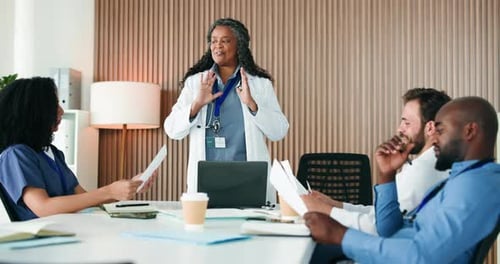Medical Professionals Meeting Discussing Paperwork in Office
