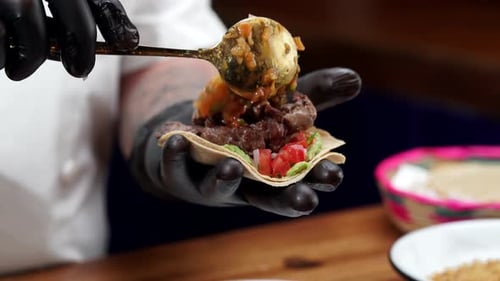 Chef Making Tasty Taco with Salsa and Meat