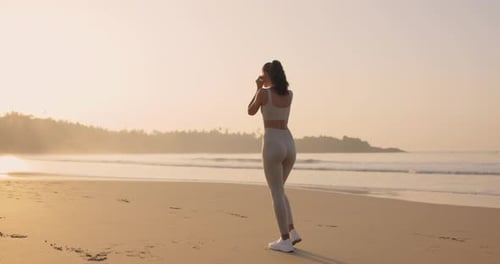 Female Runner Jogging During Outdoor Workout on the Beach in Slow Motion