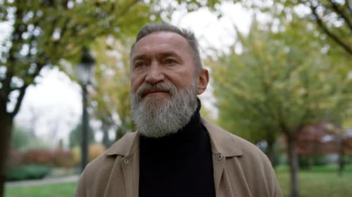 Portrait of Mature Man with Long Grey Beard Outdoors. Old Man Going