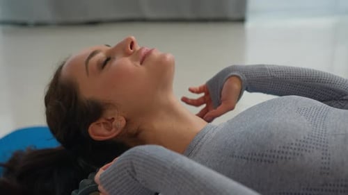 Woman Massaging Neck with Roller at Home