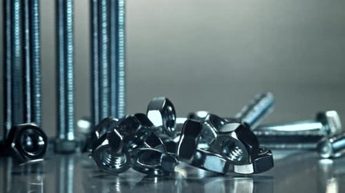 Nuts and Bolts Falling onto Silver Surface