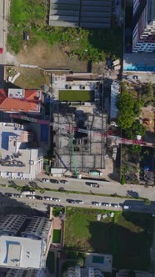 Vertical Video of Residential Construction With Workers and a Crane Collaborating to Build