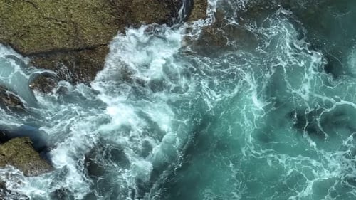 Powerful ocean waves crashing on rocky coastline.