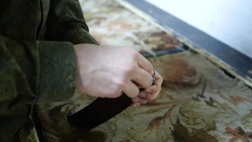 A Man in Military Uniform Loads a Machine Gun with Closeup Ammunition