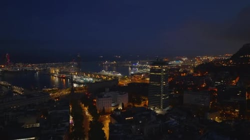 Vorwärts fliegen am Abend über die Gebäude eines Stadtbezirks und entdecken Boote und glühende Häfen