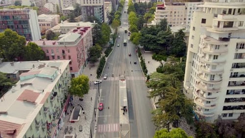 Arrêt de bus : prise de vue aérienne. Circulation dans la ville. Bus passant dans la ligne de bus