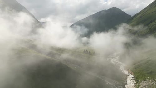 Flying Through the Clouds Above Mountain Tops