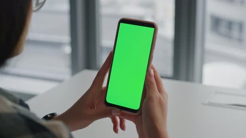 Young student hands holding mockup phone watching blogs at home indoors