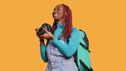 Smiling Young Woman Posing with Camera in Studio