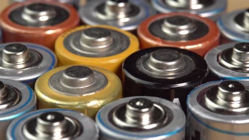 Rows of used alkaline AA batteries. Lithium ion battery pack close up. Electric power supply
