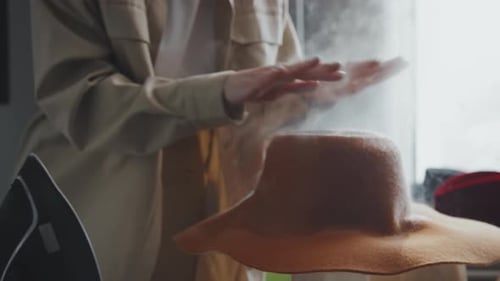 Woman Shaping Hat with Steam in Millinery Studio