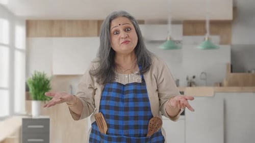 Woman Smiling and Talking in Her Kitchen