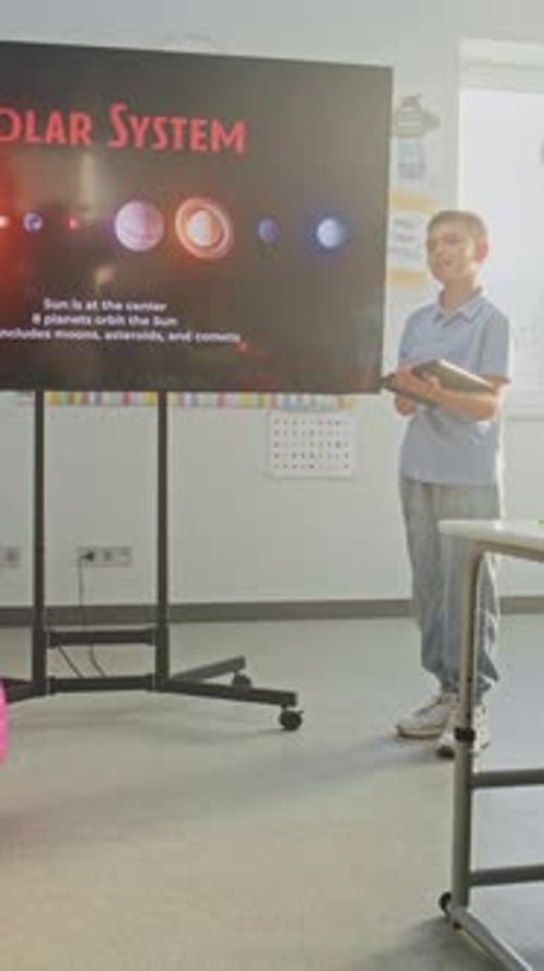 Primary School Boy Showcasing Knowledge of Astronomy in Front of Class and Teacher Using Digital