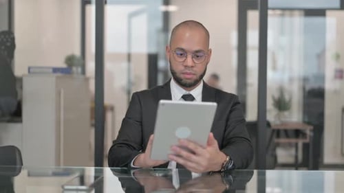 Focused Businessman Using Tablet in Bright Modern Office