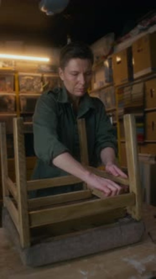 Woman Repairing Wooden Chair in Workshop