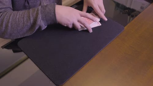 Person Shuffles Playing Cards on a Black Mat