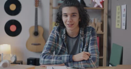 Smiling Young Adult Studies at Desk Indoors