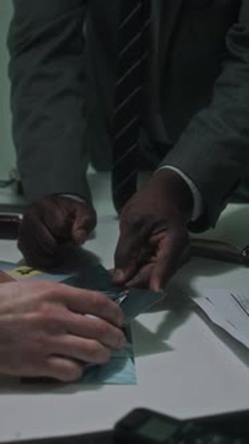 People Examining Evidence Photos at a Table