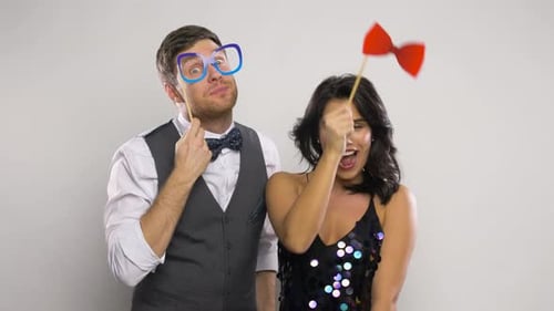 Celebration, Fun And People Concept - Happy Couple Posing With Party Props