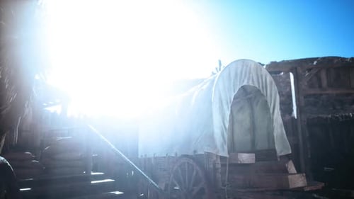 Vagón histórico bajo la brillante luz del sol en un asentamiento rústico